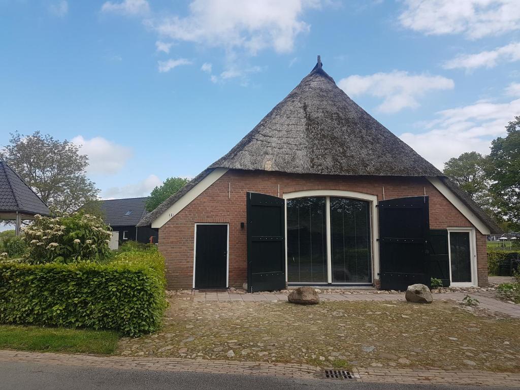 ErmErmerhoek: op de Deel的茅草屋顶的小砖砌建筑