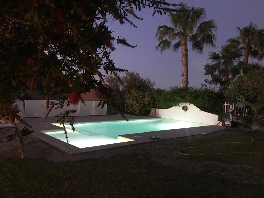 切法卢吉奥吉别墅住宿加早餐酒店的夜间在院子里的游泳池里