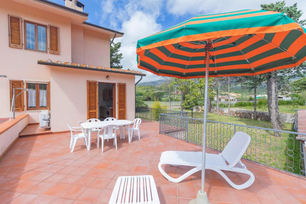 坎普码头HelloElba Appartamento Azzurro的庭院配有桌椅和遮阳伞。