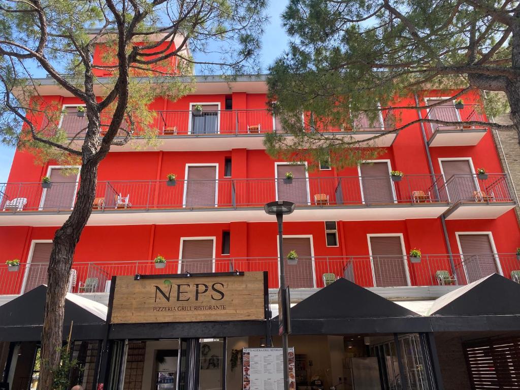 利多迪耶索罗Hotel Neps的前面有标志的红色建筑