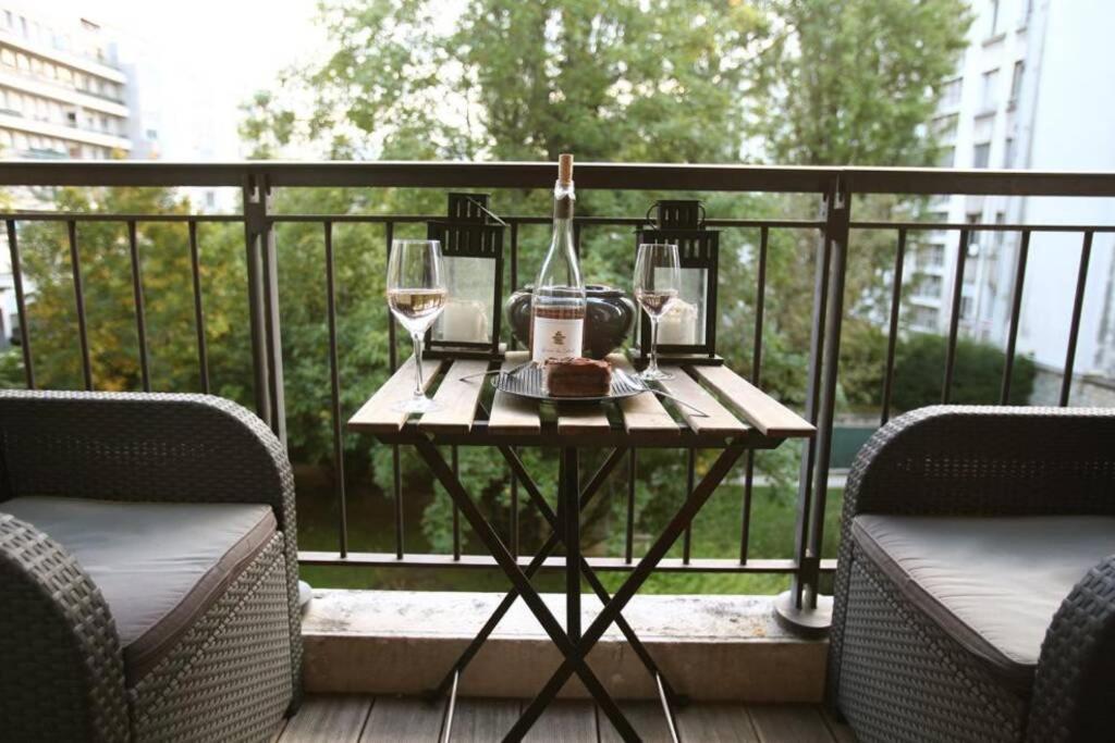 塞纳河畔讷伊George Apartment in Neuilly的阳台上的桌子和两杯葡萄酒