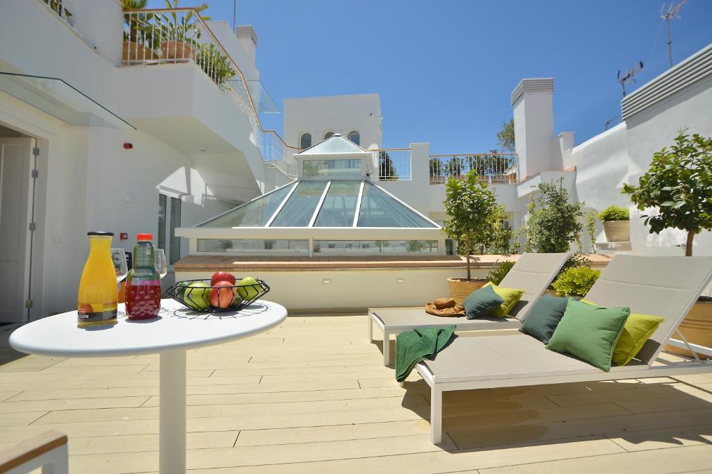 加的斯Plaza Mina Suites - Adults Recommended by Luxury Suites Cadiz的一座带两把椅子和一张桌子的庭院以及一座建筑