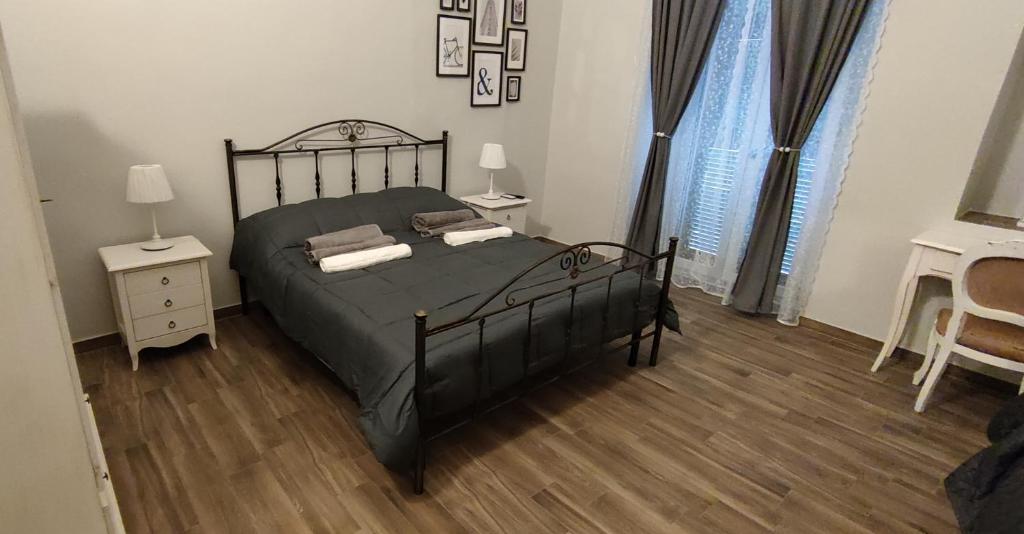 塔兰托Casa Principe Taranto "Intero appartamento"的一间卧室设有一张黑色的床,铺有木地板。