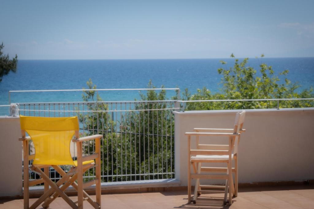 尼亚普拉加ammos seafront family apartments的两把椅子坐在一个俯瞰着大海的阳台