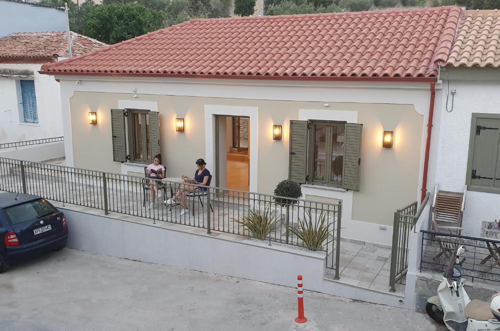 托隆Villa Fouli的两人坐在房子的阳台上