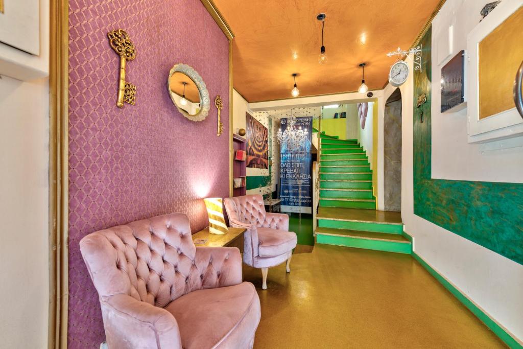 埃尔莫波利斯佛罗伦萨精品住宿加早餐旅馆的一间设有两把椅子和粉红色墙壁的房间