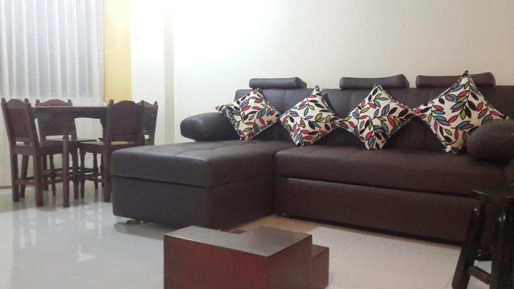 派帕Apartamentos Edificio Diamante的客厅配有带枕头的棕色沙发