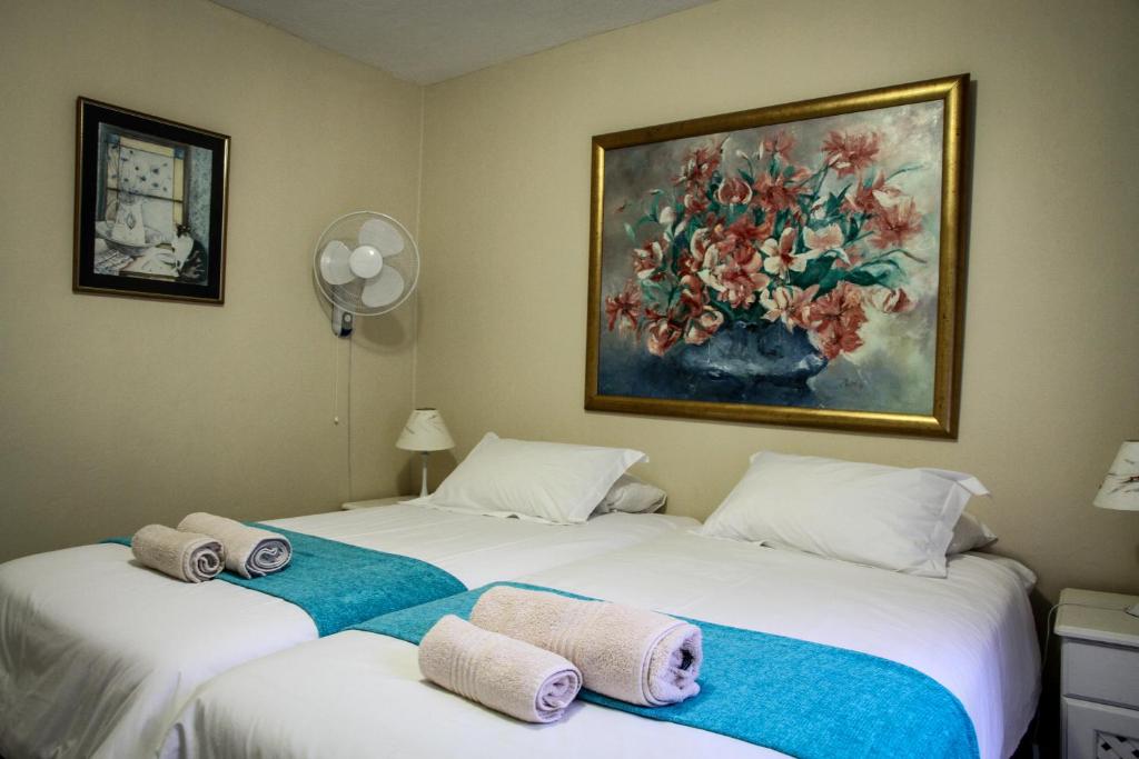 内尔斯普雷特Sunshine Self Catering的墙上画画的房间里设有两张床