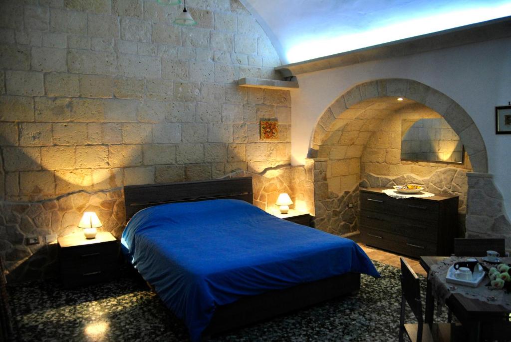 奥里亚小屋住宿加早餐旅馆的一间卧室设有蓝色的床和石墙