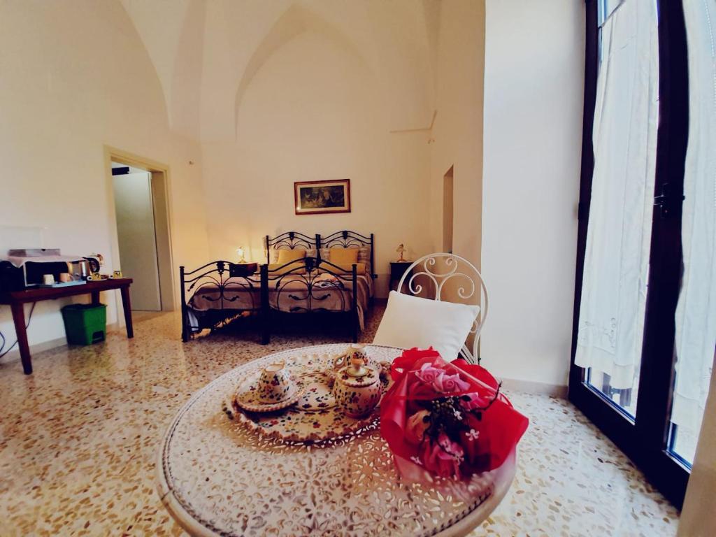 加拉蒂纳camera matrimoniale centro storico Galatina的一间房间,桌子上有一个红色的弓