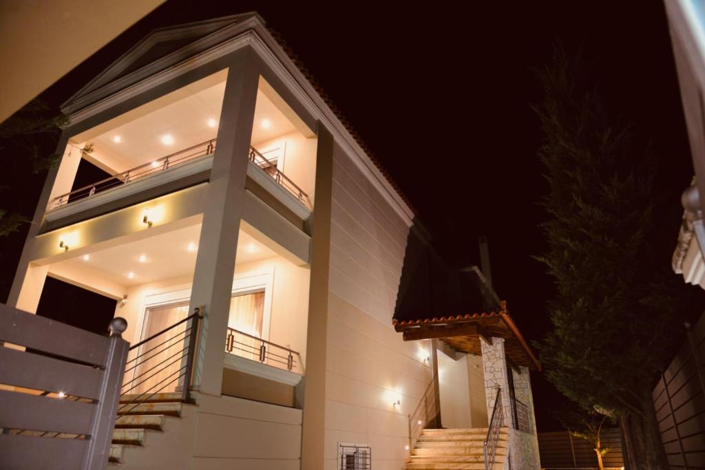纳夫普利翁Βίλα Αμαλία Ναύπλιο的白色房子,晚上设有阳台