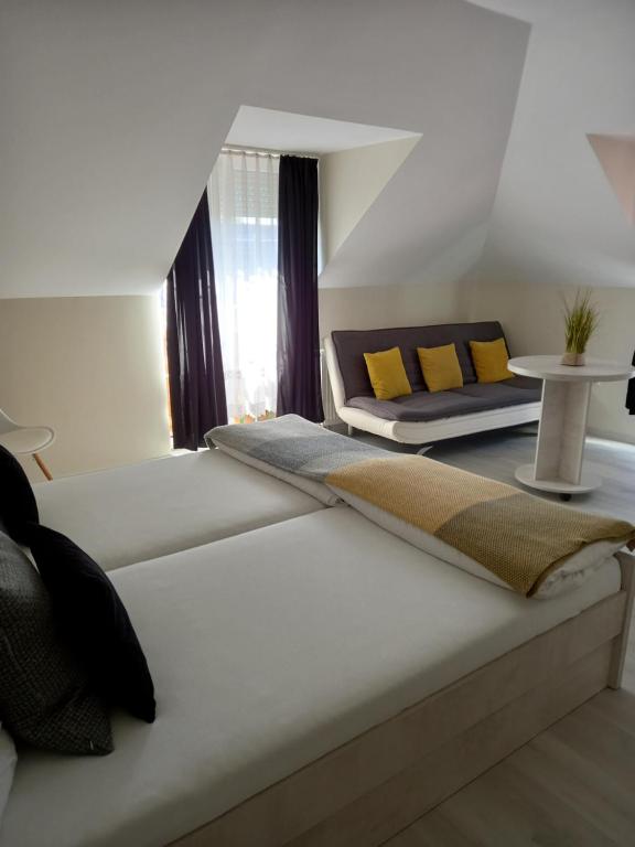 帕波维奥拉温德加住宿加早餐旅馆的一间卧室配有一张床、一张沙发和一张桌子