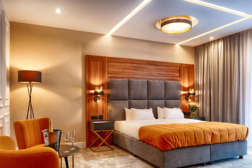 什切青Grand Focus Hotel Szczecin的配有一张床和一把椅子的酒店客房