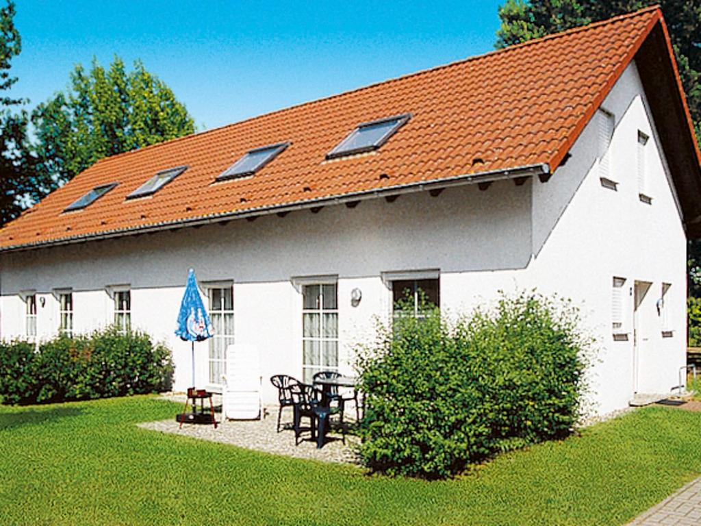 LenzHoliday Home Lenzer Höh-2 by Interhome的白色的建筑,带有橙色的屋顶,配有桌子和椅子