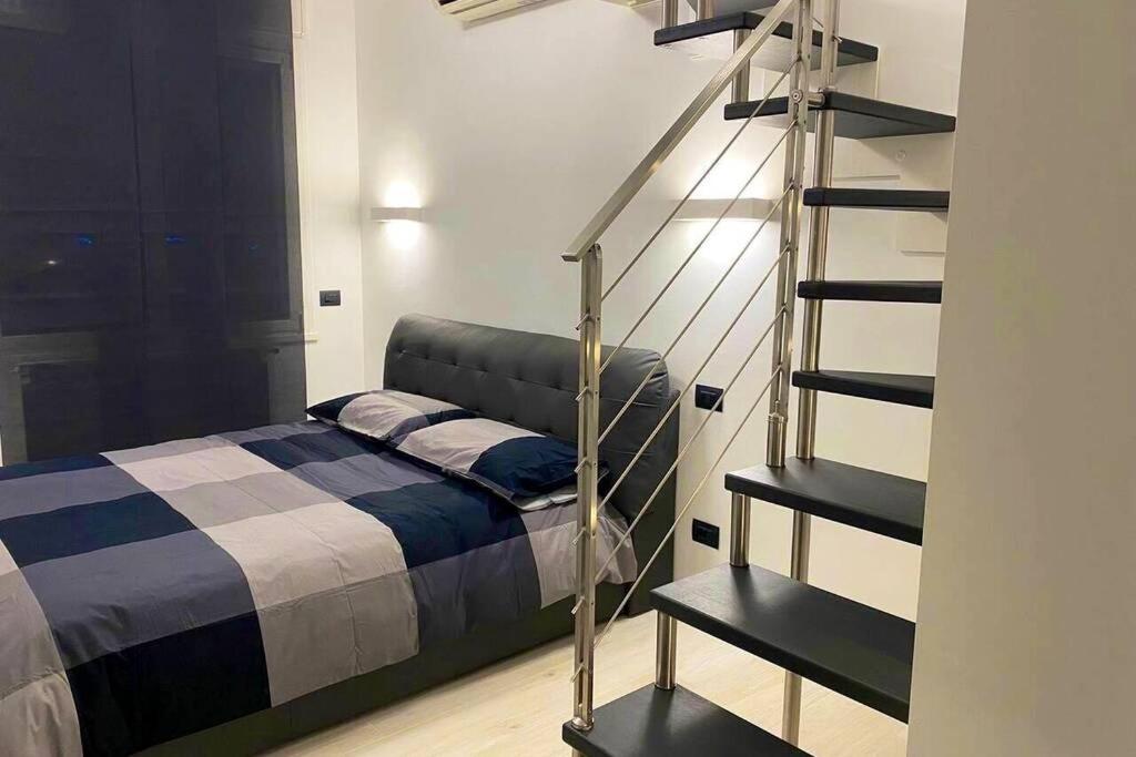 米兰ATTICO Milano-Bicocca的一间卧室设有一张床和一个螺旋楼梯