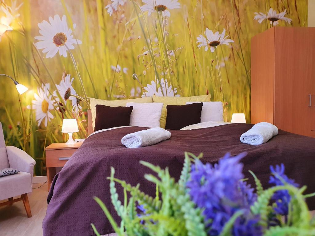 赫维兹Lavendel apartments的卧室配有一张墙上鲜花的大床
