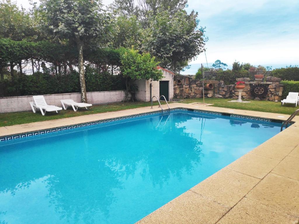 莱沃尔塔Apartamentos Revolta Sanxenxo 3000的庭院里的一个蓝色海水游泳池