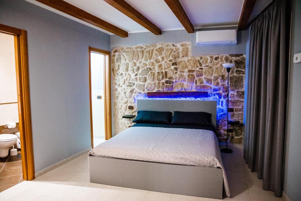 巴里Dimora L'Etual的一间卧室设有一张床和石墙