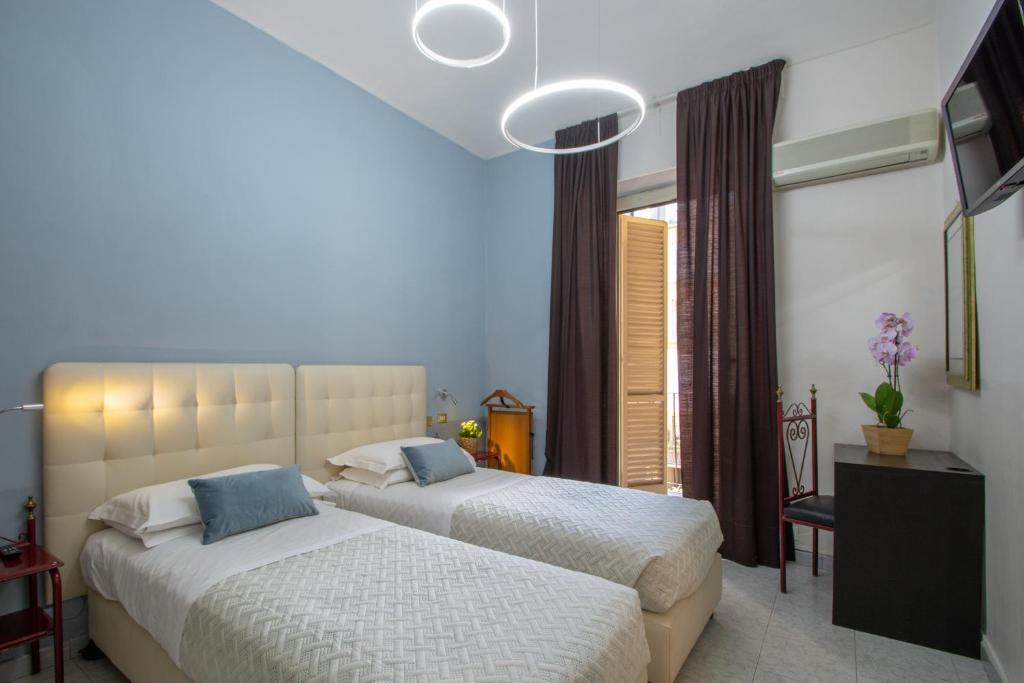 都灵意大利酒店的一间卧室设有两张床和窗户。