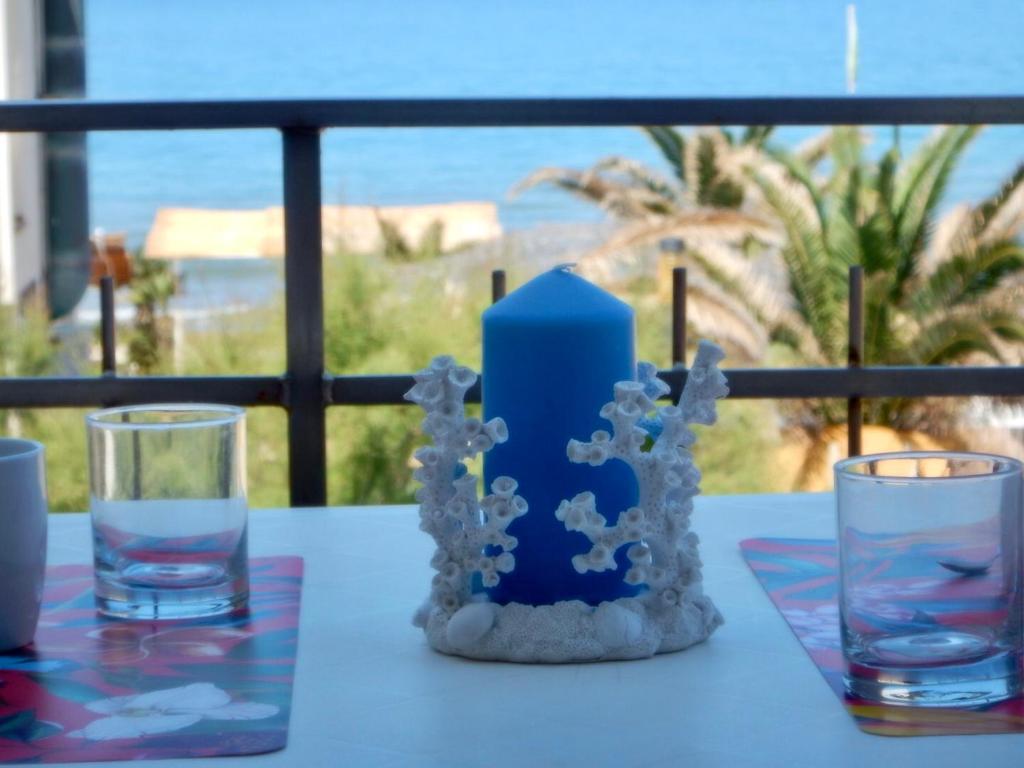 圣温琴佐Ville Paola e Daniela的一张桌子,上面有两杯眼镜和蓝色蜡烛