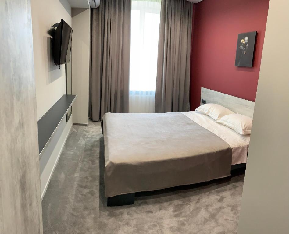 卡缅涅茨-波多利斯基Red Cube Hotel的一间卧室设有一张床和红色的墙壁
