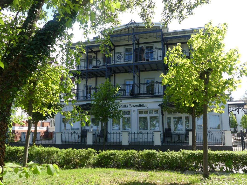 宾茨Villa Strandblick的前面有树木的白色大建筑