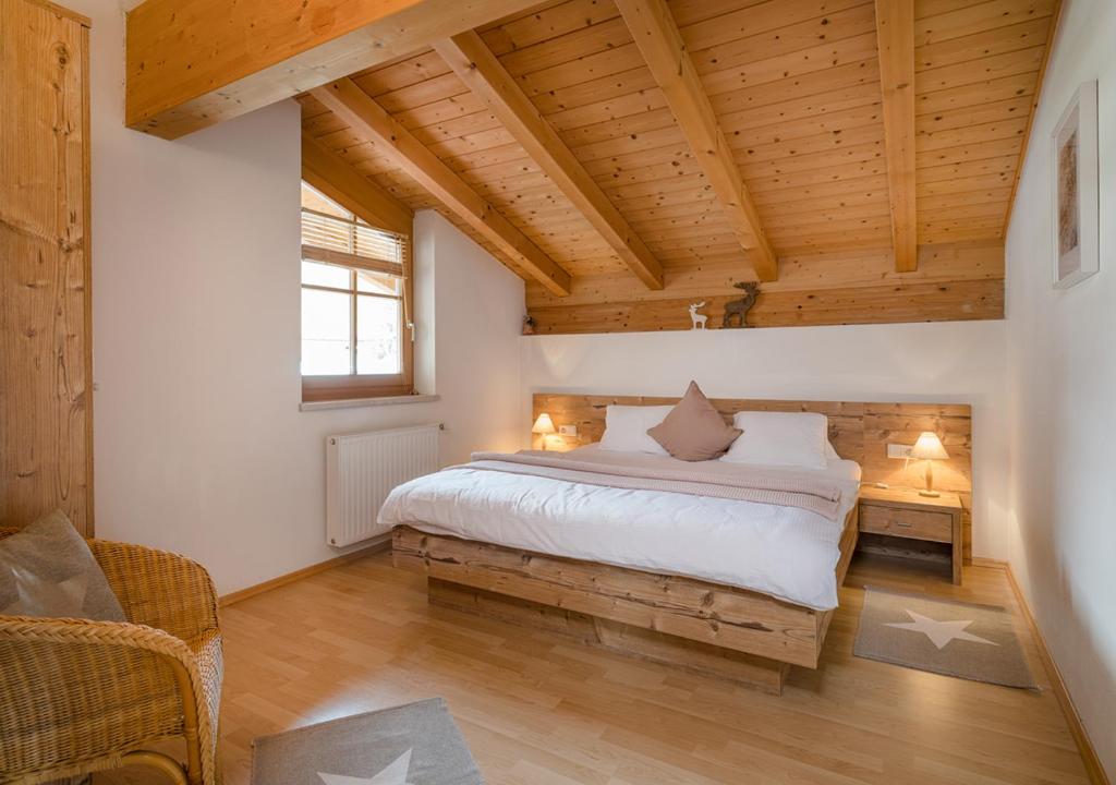 阿尔滕马克特蓬高Appartements Klausner的一间带一张床的卧室,位于带木制天花板的房间内
