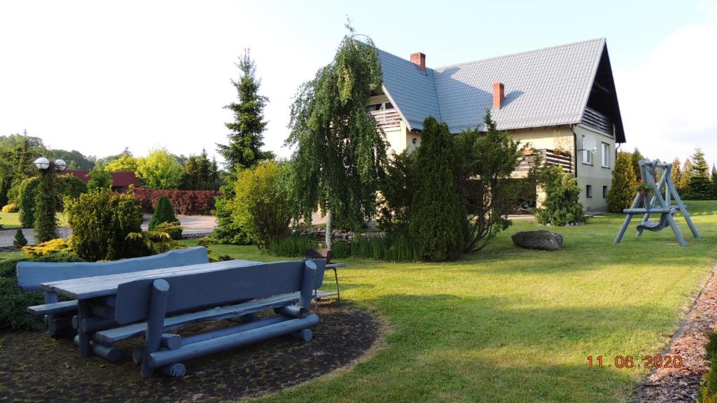 SikorzynoZielone Tarasy na Kaszubach的院子里有蓝色长椅的房子