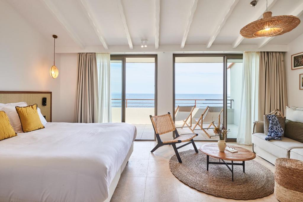 科利尤尔Les Roches Brunes的一间卧室配有一张床,客厅享有海景