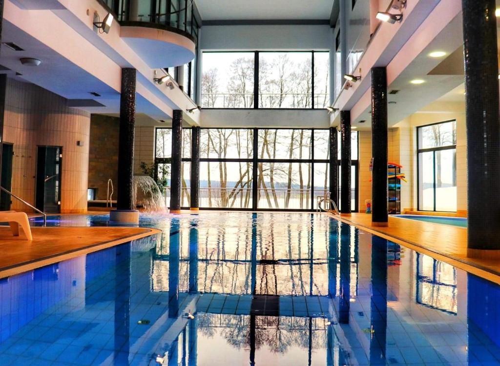 奥尔什丁Pirat Hotel & SPA-hotel z basenem的大楼内一个蓝色瓷砖的大型游泳池
