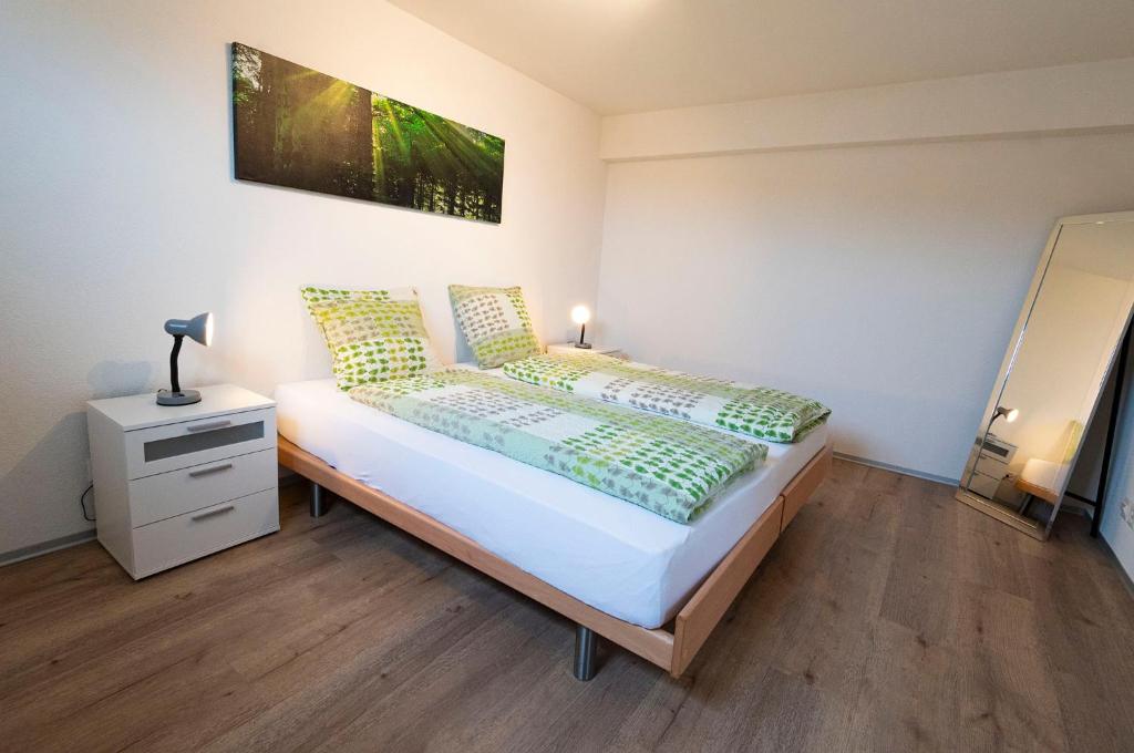 赛尼厄莱吉耶Hôtel Bellavista "Bellevue"的一间卧室配有一张带床头柜的床和一张四柱床。
