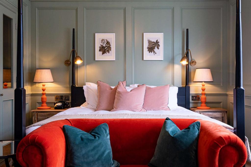 浦耳The Canford的一间卧室配有一张带红色沙发和两盏灯的床。