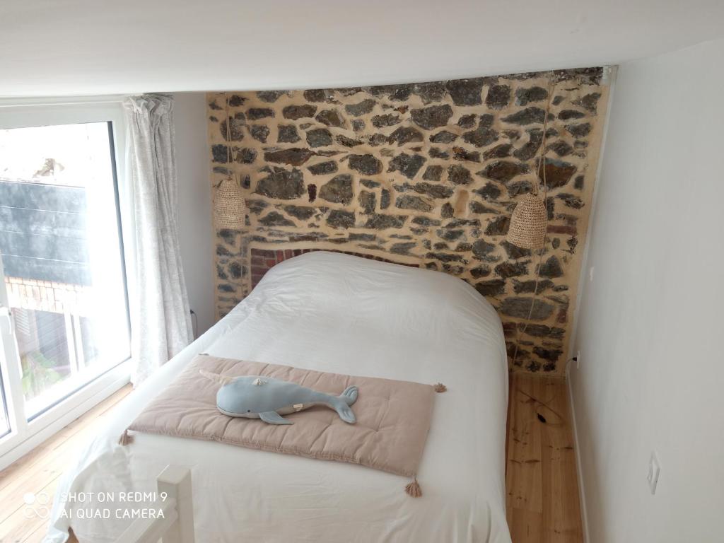 格朗维尔Charmant logement T2 à 2 pas de la mer的一间小卧室,配有一张石墙床