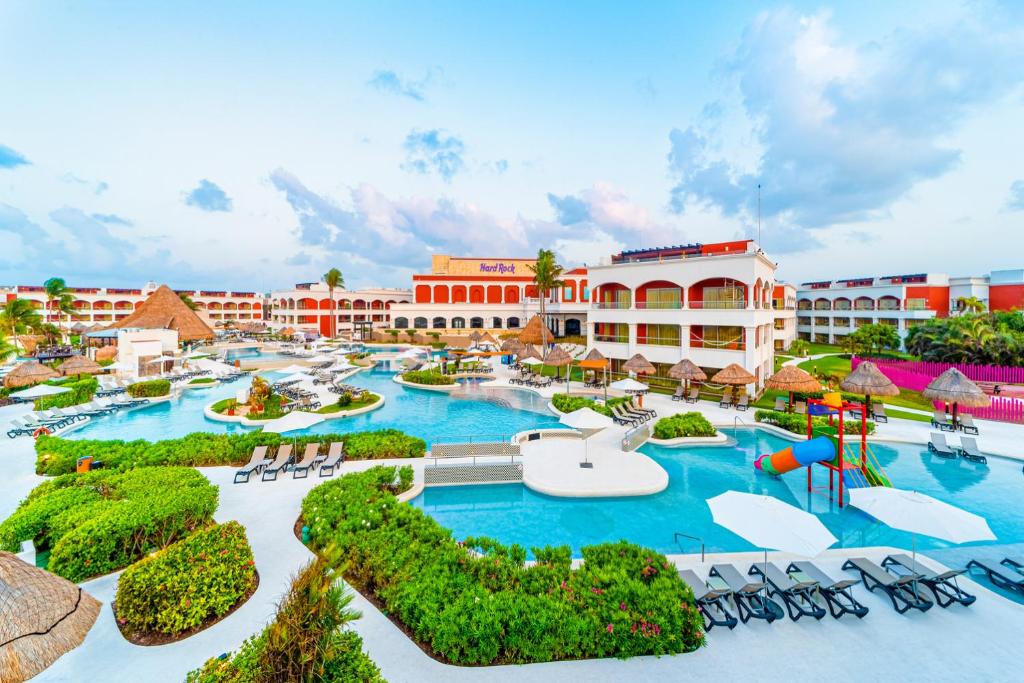 阿文图拉斯港Hard Rock Hotel Riviera Maya度假酒店- 全包的一个带椅子的游泳池和游乐场的度假村
