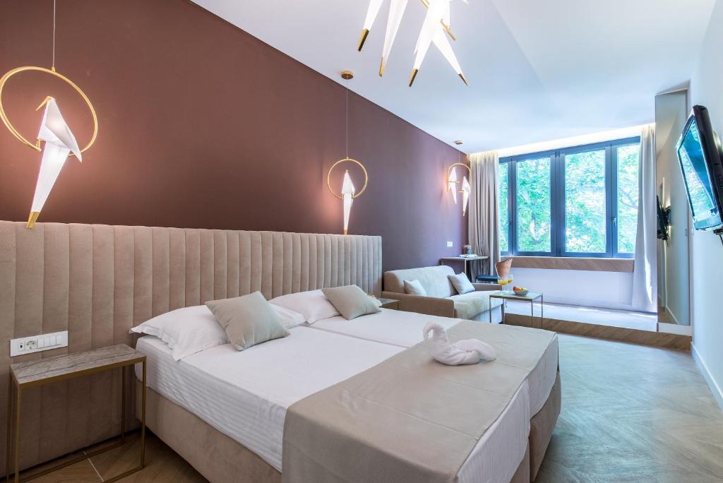 斯普利特Bošket Luxury Rooms的一间卧室配有一张大床和一张沙发