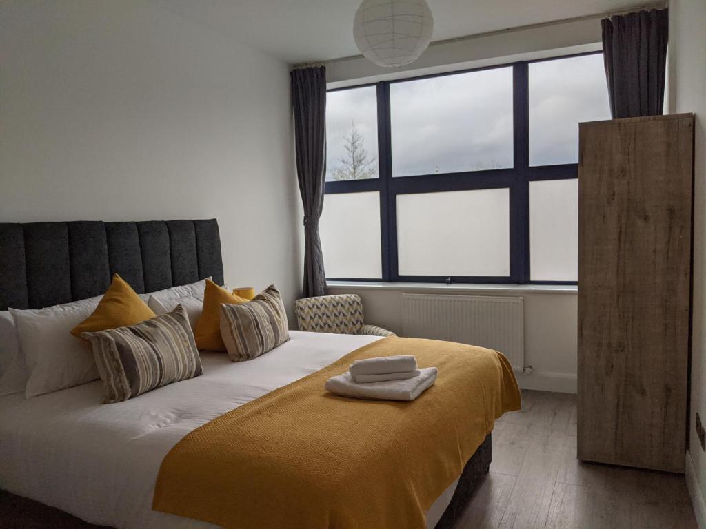 特尔福德Sapphire House Telford的一间卧室配有一张带黄色毯子的大床