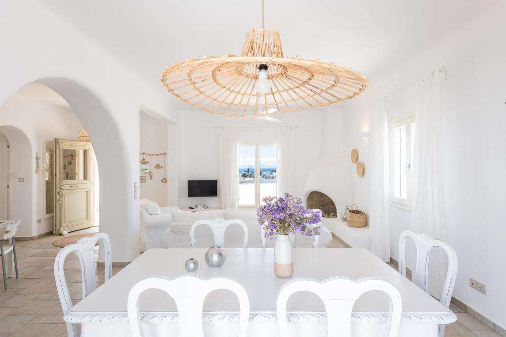 艾丽奇Irene's House in Aliki的白色的用餐室配有白色的桌子和白色的椅子