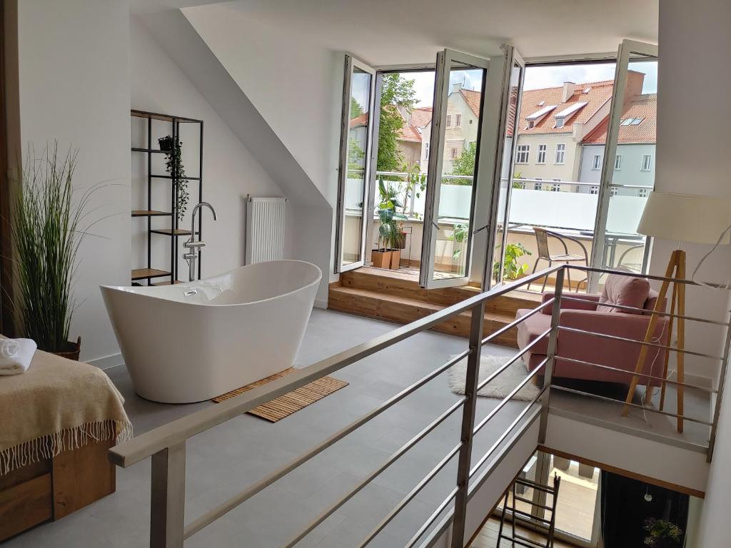 姆拉哥沃B&N Apartments的一间带浴缸的浴室,位于玻璃柜台上