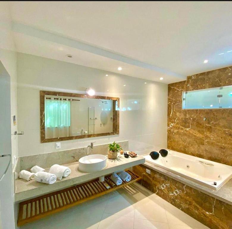阿拉亚尔达茹达Pousada Arraial Charme的浴室配有盥洗盆和浴缸。