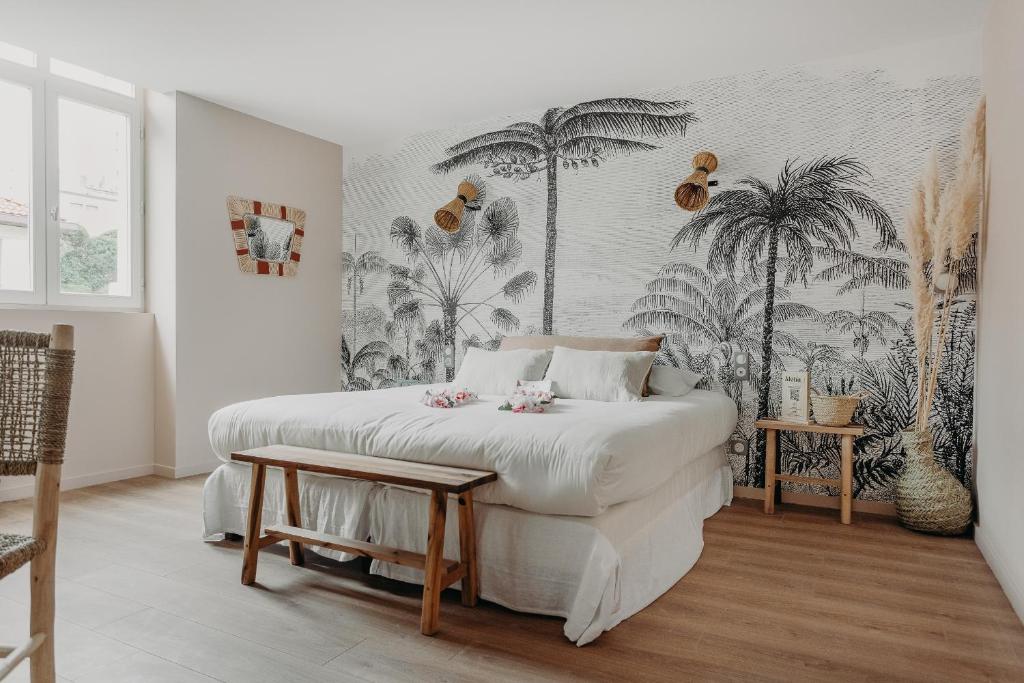 比亚里茨Hôtel PALMITO的一间卧室,配有床和棕榈树壁画