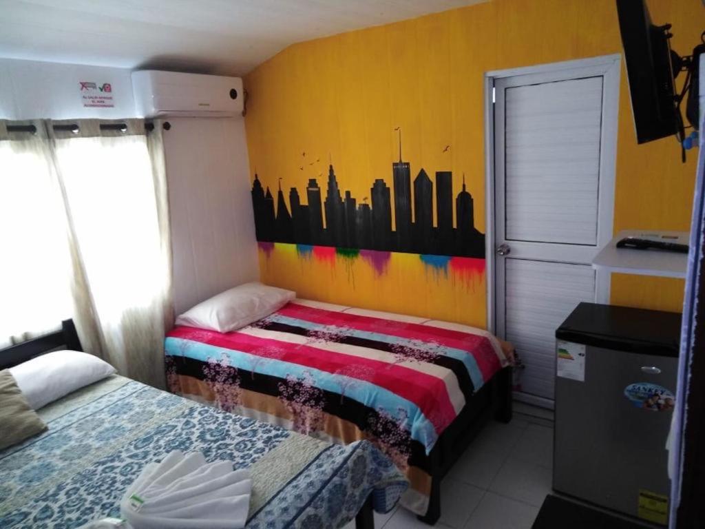 圣安德烈斯Cabañas 7 Colores的一间带两张床的卧室和墙上的城市壁画