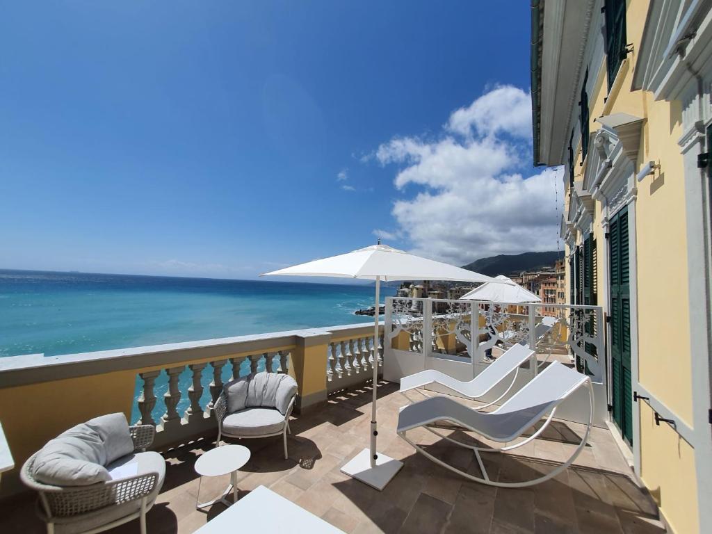 卡莫利Sublimis Boutique Hotel Adults-Only的一个带椅子和遮阳伞的阳台,并享有海景。
