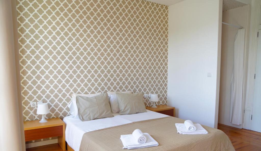 Lagares da BeiraHostel Casa do Pinheiro的一间卧室配有一张床,上面有两条毛巾