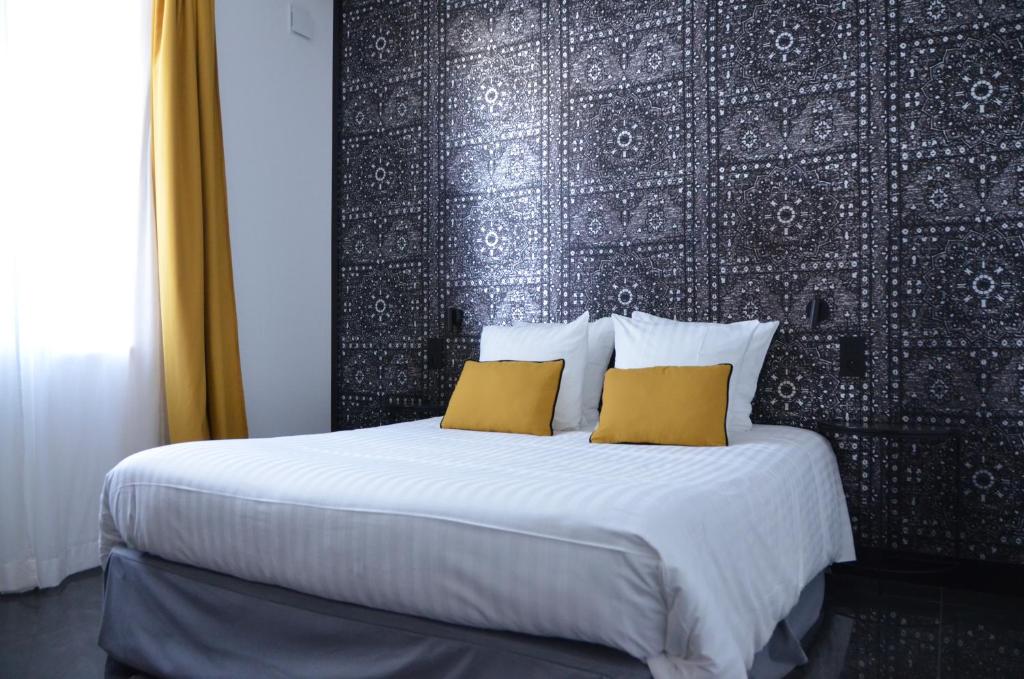 波讷地区帕朗提CHEZ FLO的一间卧室配有一张大床和两张黄色枕头