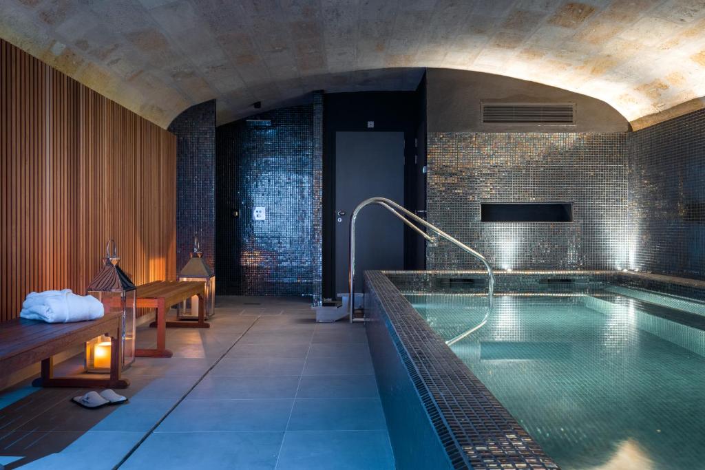 波尔多Villas Foch Boutique Hotel & Spa Bordeaux的大楼内带大型游泳池的浴室