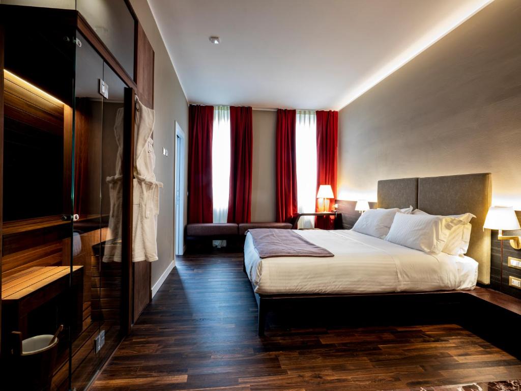 米兰10 KEYS MILANO的酒店客房设有一张大床和红色窗帘