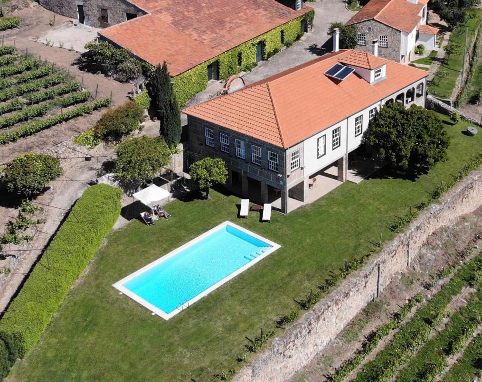 拉梅戈Quinta da Portela - Casa Visconde Arneiros的享有带游泳池的房屋的空中景致