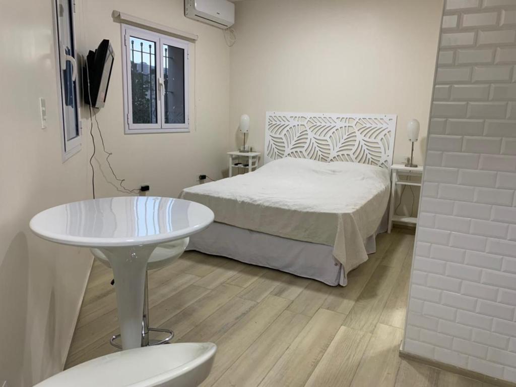 圣米格尔·德·图库玛Monoambiente Plaza Belgrano的一间卧室配有一张床、一张桌子和一张桌子