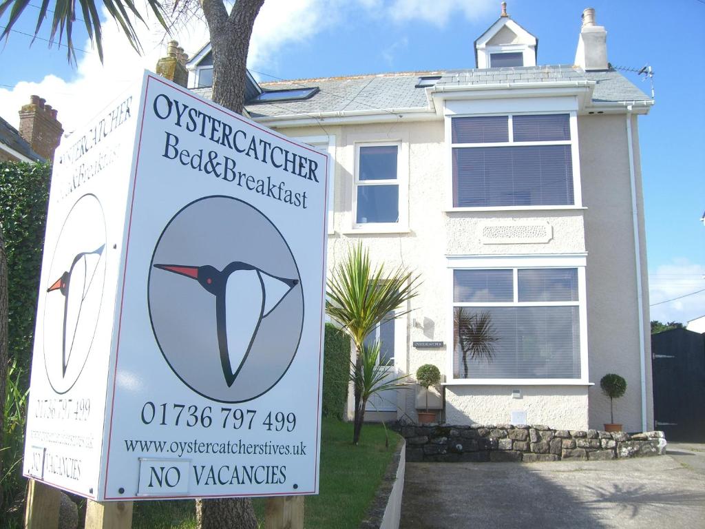 圣艾夫斯Oystercatcher的白色房子前面的标志