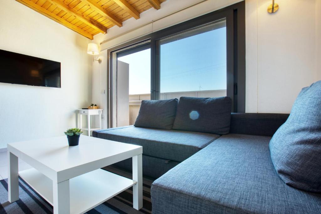 切什梅AEGEAN Apartments - Marina & Chios Island View的客厅配有沙发和桌子